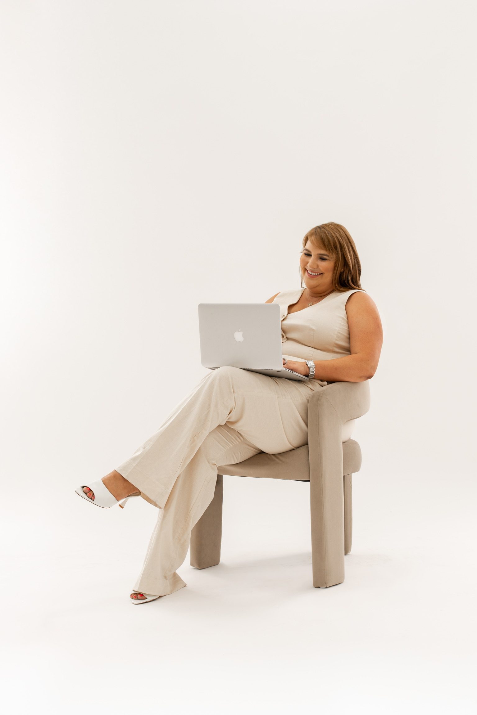 Lauren smiling while seated with her laptop